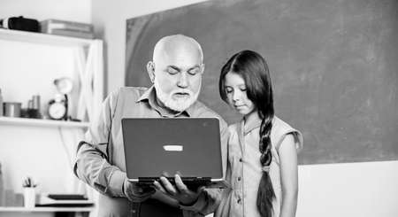 school shopping online. cyber monday. online education. Back to school. small girl with man tutor study on laptop. senior teacher help school girl. modern technology. Dont Mess with The Bestの写真素材