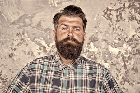 be the real man. serious man with lush beard and moustache. confident male hipster after barbershop. professional hairdresser in checkered shirt. brutal bearded man grunge backgroundの写真素材