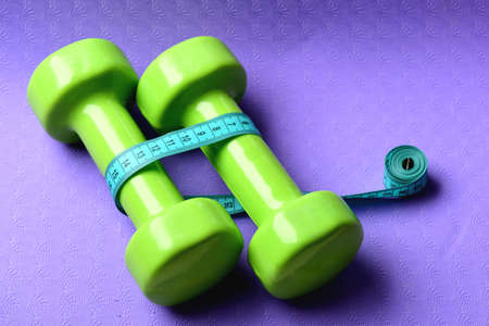 Barbells in small size next to cyan rulerの写真素材