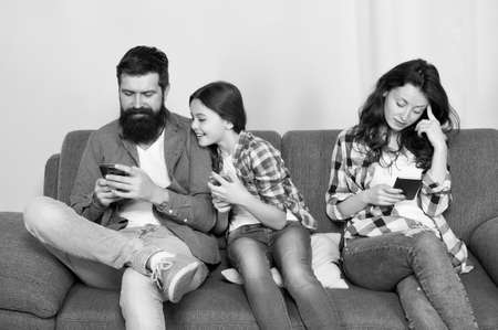 Hooked on phone. Family play mobile phone game at home. Staying connected with cell phone. Family communication. Phone dependence. Modern life. New technology. Online gamingの写真素材