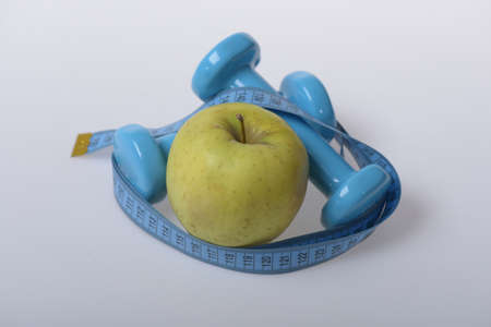 Dumbbells in bright green color, measure tape and fruit