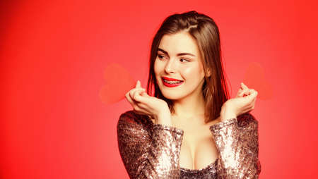 How to kiss with braces. Woman makeup red lips hold heart symbol love. Valentines day concept....