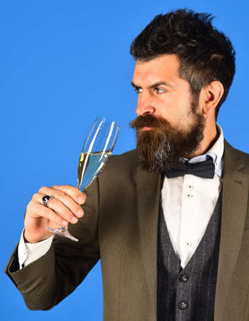 Manager with beard holds glass of champagne.の写真素材