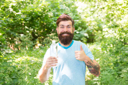 Heat Stroke Can Kill. Confident handsome brutal man. brutal caucasian hipster with moustache. Bearded man drink water. ready for camping. male happy tourist feel thirsty. sport and fitness clothesの写真素材