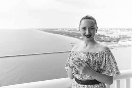 Life is good. Sexy woman on balcony with sea view. Beauty look of pretty woman. Sensual woman hold...
