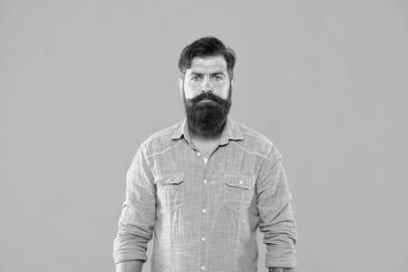 In his own style. Serious man orange background. Bearded man in casual denim style. Menswear store....