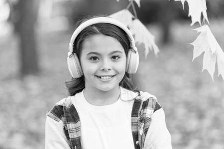 Simply music feelings. Cute little child listen to music playing in stereo headphones. Adorable girl enjoy music on autumn landscape. Feel the vibe, feel musicの写真素材