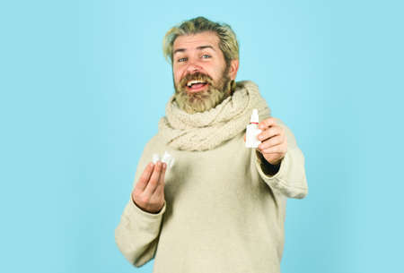 Sick leave. Cold flu remedies. Man scarf hold nasal spray. Medicines effective recovery. Allergy medical treatment. Health problem. Runny nose recovery. Runny nose and symptoms of cold. Fast recoveryの写真素材