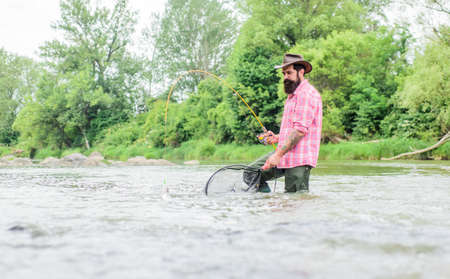 Fishing provides that connection with whole living world. Fishing hobby. Bearded fisher catching...
