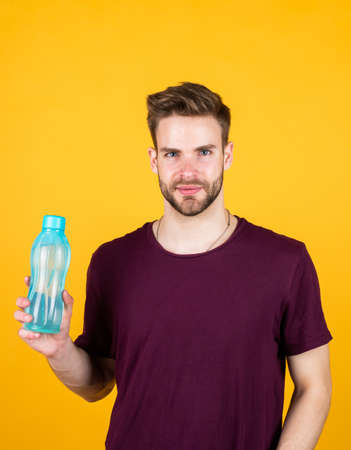 detoxifies. handsome guy hold water bottle. hydration and hydro-balance. sport and health. refreshing while fitness. water balance in body. healthcare. man drink water after active trainingの写真素材