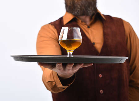 Bearded man holds glass with alcohol on white background.