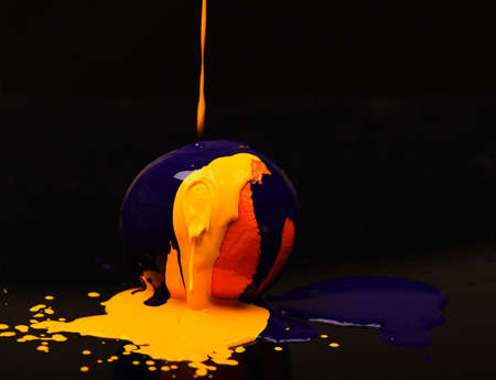 Nutrition and food art concept. Paint splashing on orange fruit.の写真素材