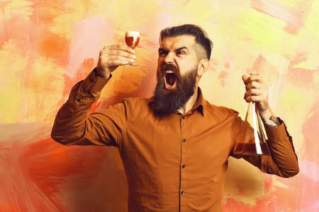 Brutal hipster holding alcoholic shot and glass tube or flask