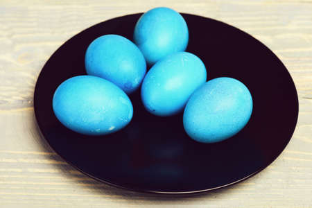 traditional easter eggs painted in blue color on black plate