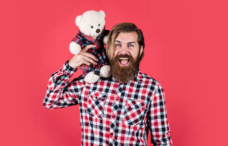 cheerful bearded man hold teddy bear. male feel playful with bear. brutal mature hipster man play with toy. happy birthday. being in good mood. happy valentines day. Valentines day salesの写真素材