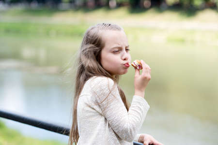 Enjoying every bite. Kid girl eat cookie. Health and dieting concept. Dieting counting calorie. Break her diet for sweets. Outdoors snack. Delicious cookie healthy snack. Sweet cookie pure enjoymentの写真素材