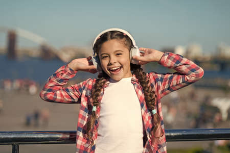 Listen for free. Get music family subscription. Access to millions of songs. Enjoy music everywhere. Best music apps that deserve a listen. Girl child listen music outdoors with modern headphonesの写真素材