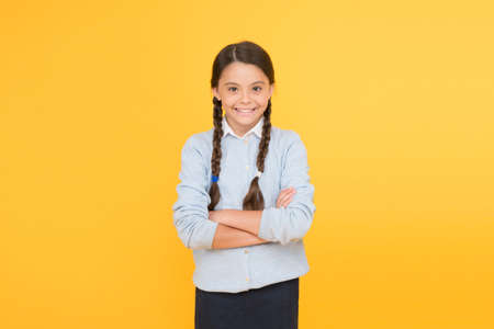 Congratulations. smart little girl on yellow background. knowledge day. childhood happiness. education concept. back to school. happy girl in school uniform. kid fashion. school marketの写真素材