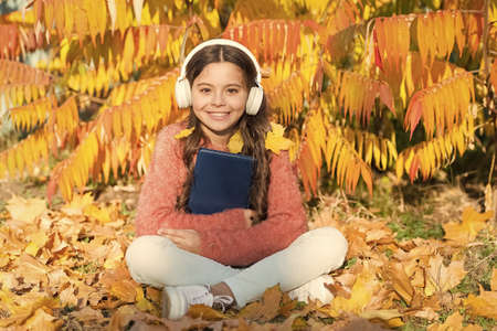 Self education concept. Child enjoy reading. Visual and audio information. Little child enjoy learning at backyard. Kid study with book. Schoolgirl study. Study every day. Girl read book autumn dayの写真素材
