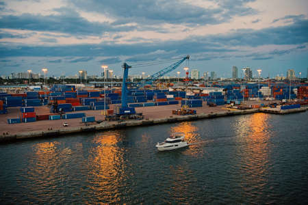 Miami, USA - March 01, 2016: sea port at dusk. Commercial terminal. Containers on pier with freight crane. City skyline. Maritime transport and transportation. Cargo shipping. Shipmentのeditorial素材