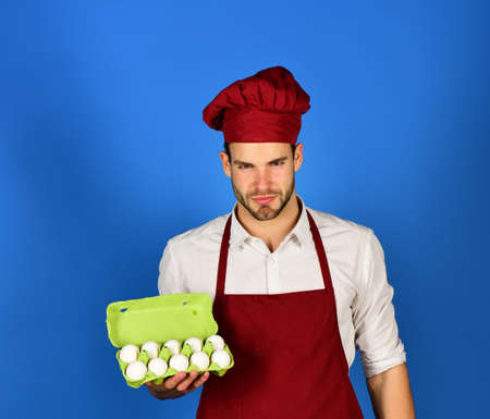 Dairy meal concept. Man in cook uniform with ten eggs