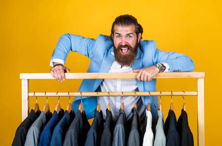 dry cleaning service. style and people concept. Handsome man in smart casual wear looking at suits...