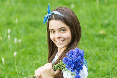 Little girl cornflowers bouquet holiday greetings, happy childrens day conceptの写真素材