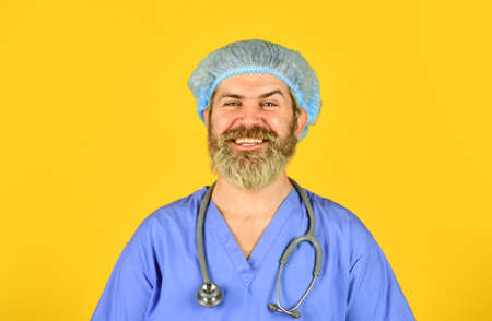 Man bearded doctor wear uniform cap. Hipster work at hospital. Health care. Doctor occupation. Medical insurance. Incubation period. Doctor ready to help. Diagnosis concept. Global health emergencyの写真素材
