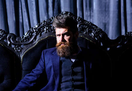 Bearded man with serious face in classic interior.