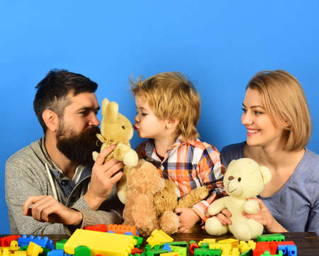 Parents and kid cuddle with toys. Family with happy facesの写真素材