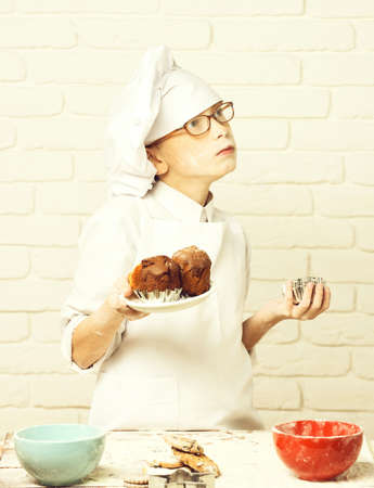 stained cute cook chef boy on brick wall background.