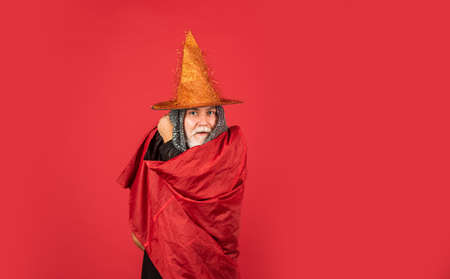 Add magic to your life. Halloween party. witch man in hat and cloak. happy halloween. Weird old grandfather with gray beard. Devil man. Holiday and celebration. Magic hat. Best ideas for Halloweenの写真素材