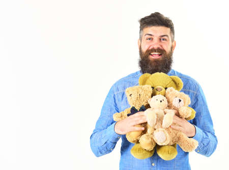 Guy with beard hugs soft toys with tenderness.