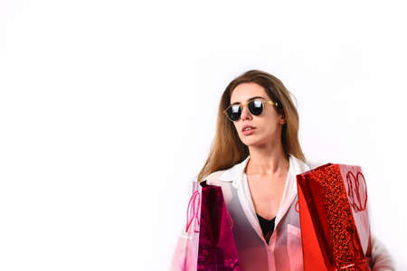 Woman with packages. Girl in sunglasses with serious face