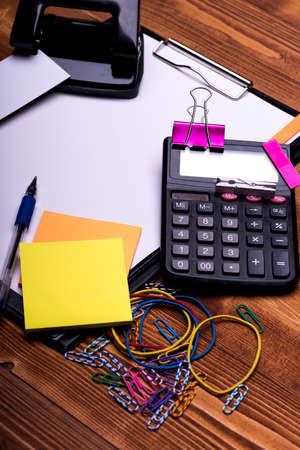 Business cards and binders near sticky notes and puncher