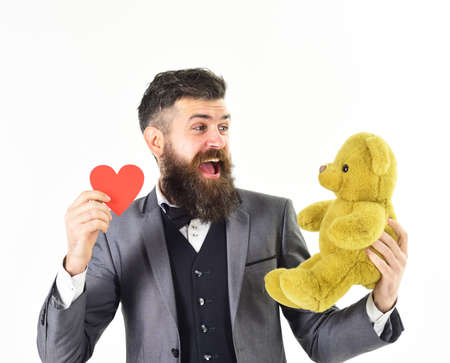 Man in suit with smiling face holds plush bear.の写真素材