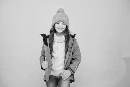 Winter vacation. Protective clothes. Winter collection. Child wear hat gloves jacket. Active leisure. Sporty style. Carefree childhood. Cute girl enjoy winter season. Little kid wear knitted hatの写真素材