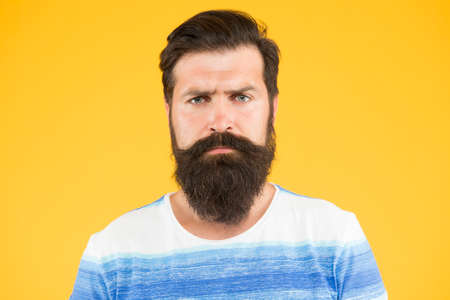 Be serious. Hipster appearance. Beard fashion and barber concept. Man bearded hipster stylish beard and mustache yellow background. Barber tips maintain beard. Stylish beard and mustache careの写真素材