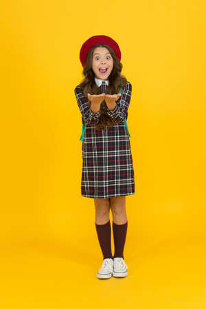 wow. surprised child ready for schoolyear. education. knowledge day. happy childhood. french style concept. back to school. retro girl wear uniform and parisian beret. kid school fashionの写真素材