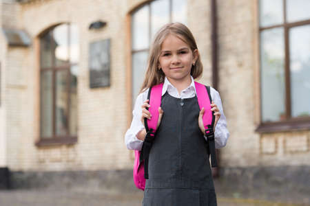 Small kid in formal fashion uniform carry school bag outdoors, schoolingの写真素材