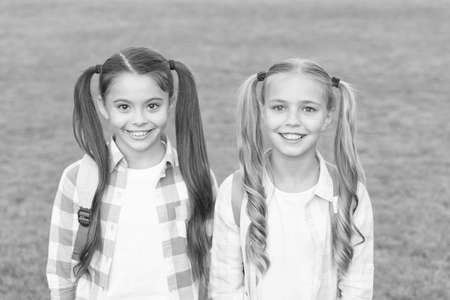 September. Vacation is over. Back to school. Cute schoolgirls with long ponytails. Ending of school...