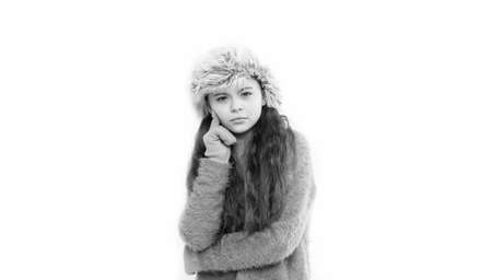 Anti static hair product. Static and frizz. Adorable child long hair soft fur hat. Child care concept. Girl long hair wear fur hat white background. Winter shampoo and conditioner prevent hair damageの写真素材