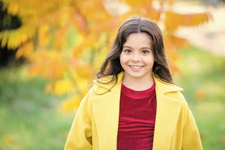 Upcoming events. Autumn beauty. Girl smiling face walking in park. Trendy girl in autumn coat. Weather forecast. Happy little child outdoors nature background. Autumn warm weather. October to do listの写真素材