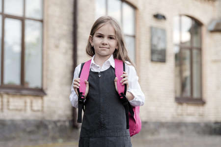 Opportunities for learning. Small kid go to school carrying bag. Back to school supplies. Fashion uniform. Formal dress code. Schoolwear. Knowledge day. Primary education. September 1の写真素材