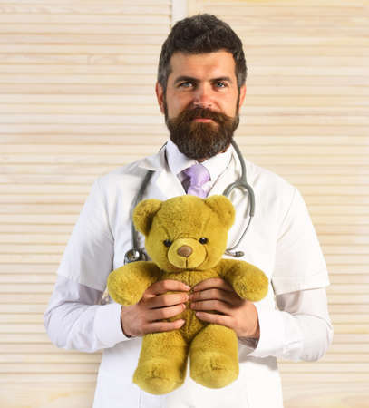 Man in surgical uniform with stethoscope on neck and toy