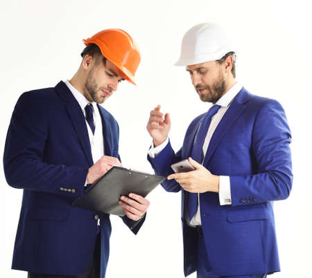 Architect and engineer discuss project. Business partners look at building plan.の写真素材