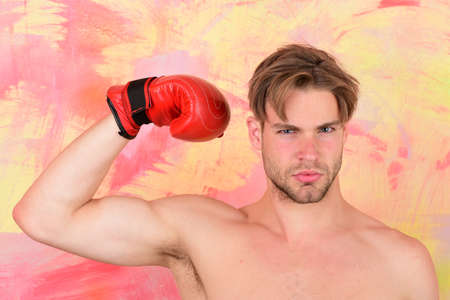 Guy with naked chest wears red leather boxing glove