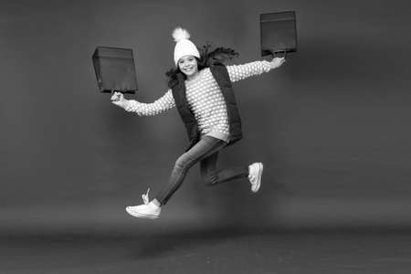 Surfing on sales wave. Trends and brands. Towards discounts. Happy girl jump with shopping bags....