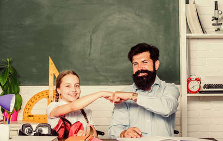 Discipline upbringing. Man bearded pedagogue study together with kid. Study is fun. School teacher and schoolgirl. Lesson is finished. Task successfully done. Homeschooling with father. Help studyの写真素材