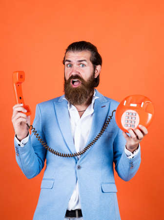 Fellow On The Phone. young man talking on telephone. businessman talking on vintage phone. Male talking on landline phone. vintage technology in modern life. line is busy. Caring firstの写真素材
